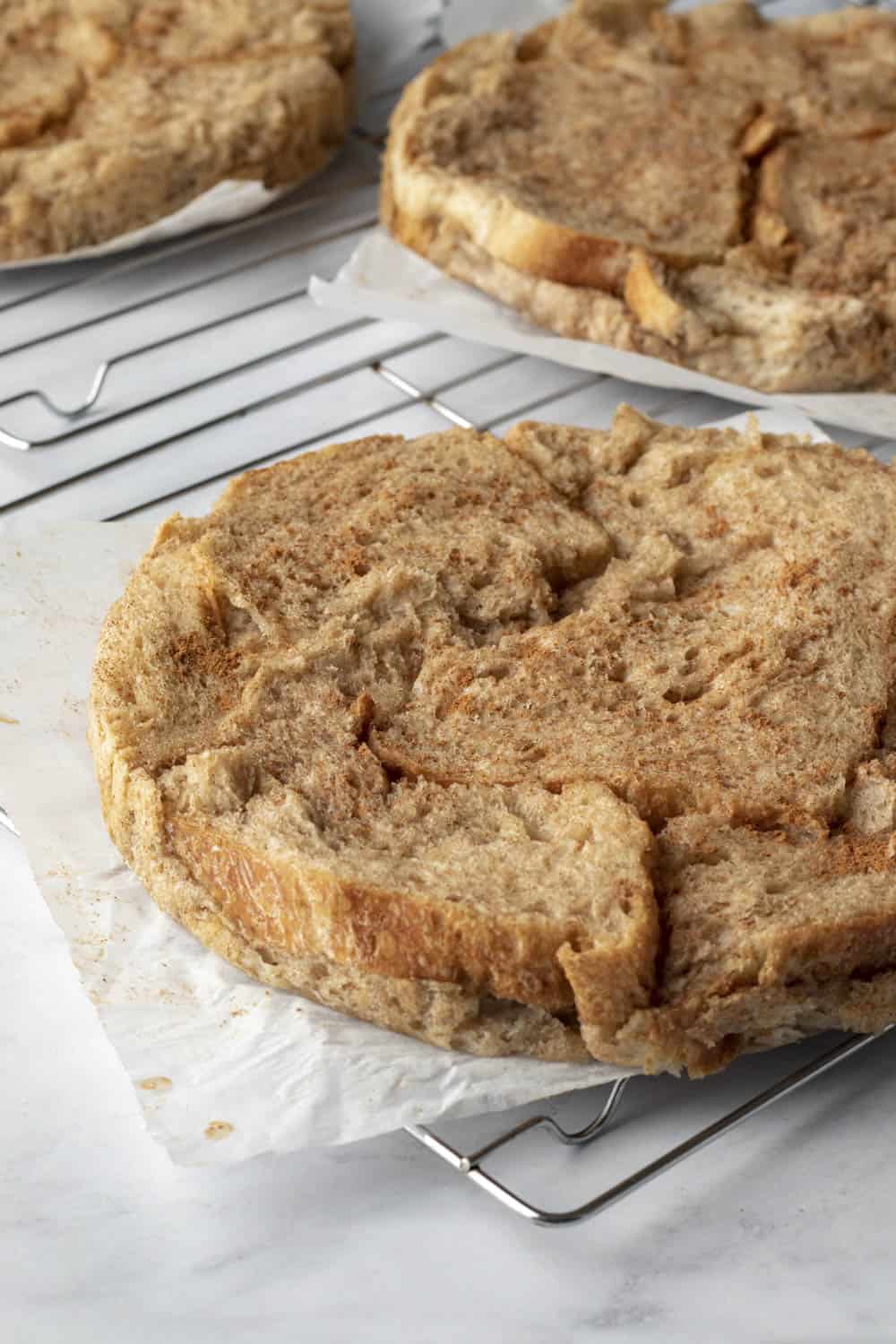 The layers of baked French toast cooling on wire racks.