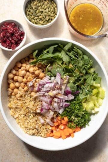 Cooked bulgur and all of the other salad components in a large bowl, ready to be mixed.