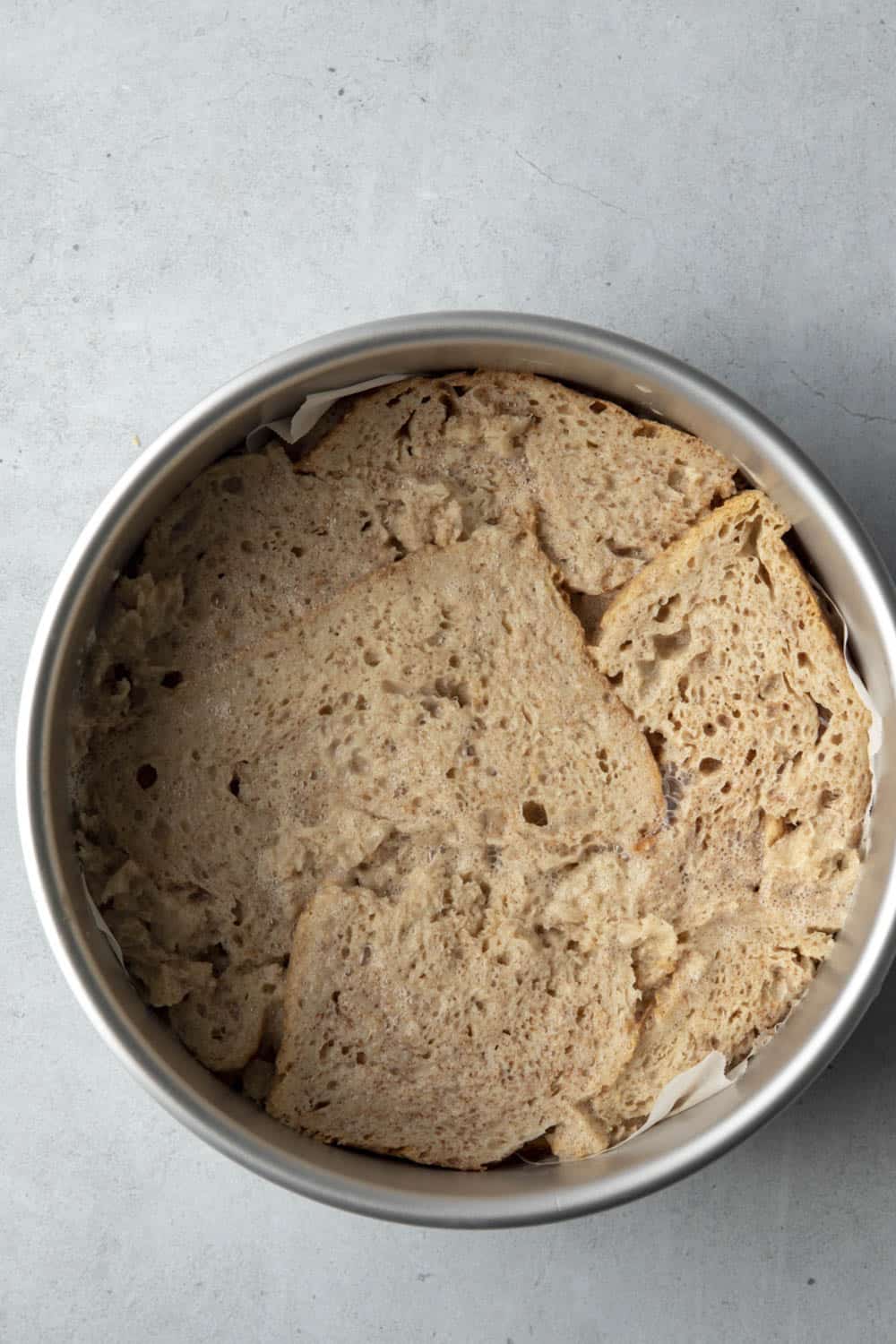Bread soaked in batter and pieced together in a round cake pan.
