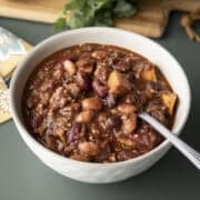 A bowl of thick vegan chili made with sweet potato, beans, and lentils.