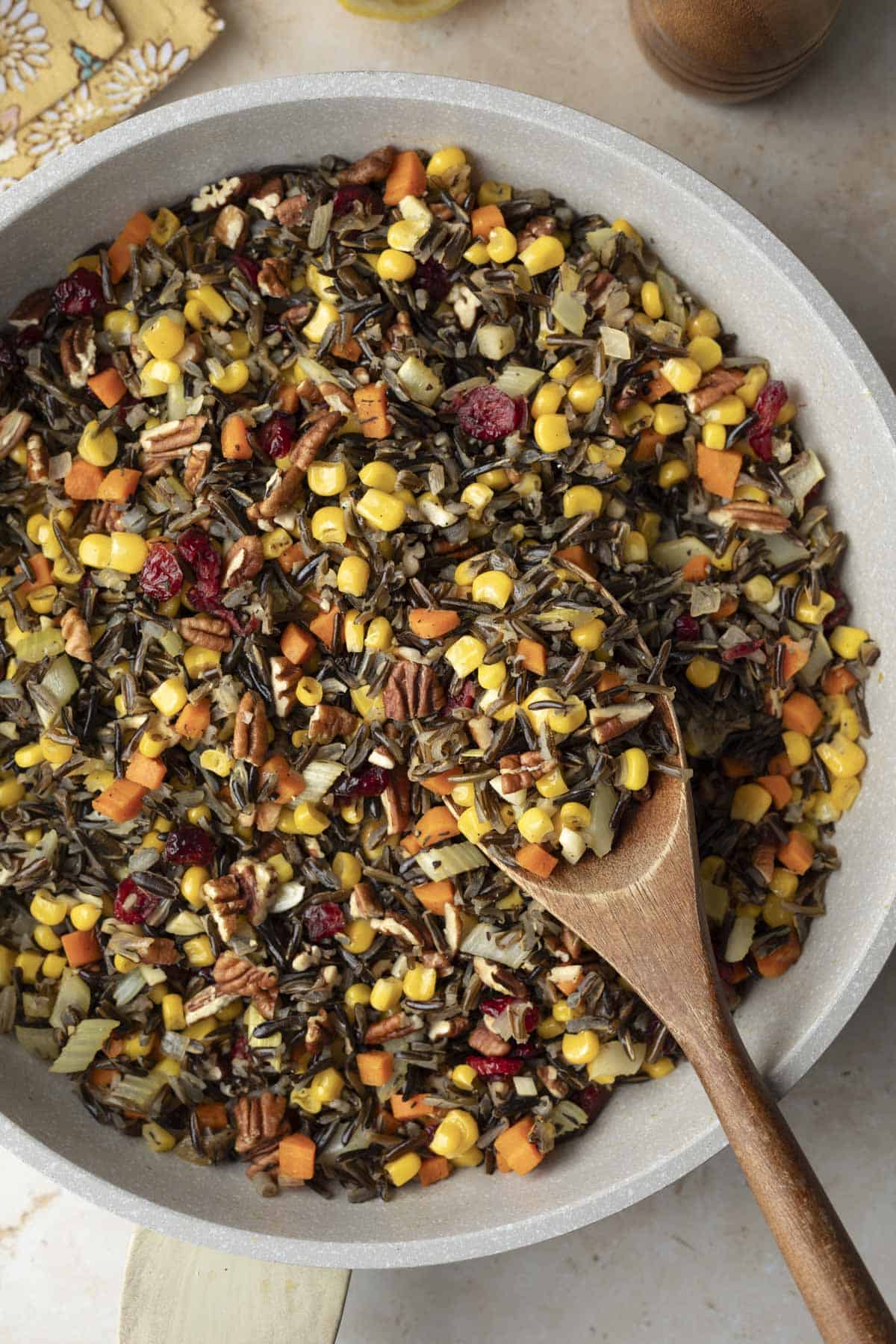 A pan full of colorful wild rice pilaf with fall vegetables and cranberries.