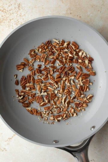 Dry-toasting chopped pecans in a skillet.