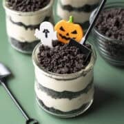 Dirt cups for Halloween decorated with small shovels, ghosts, and pumpkins.
