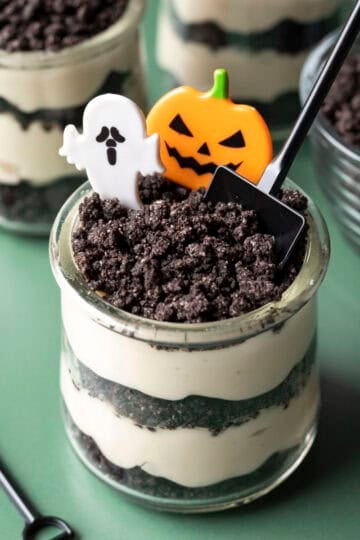 Dirt cups for Halloween decorated with small shovels, ghosts, and pumpkins.