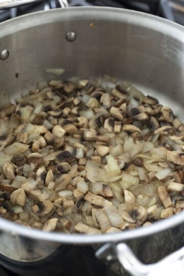Sauteing onion and mushrooms for the creamy casserole sauce.