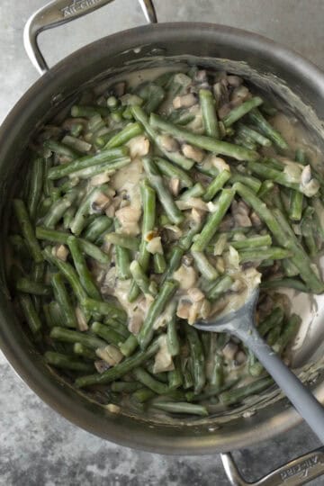 Tossing the green beans with creamy mushroom sauce.