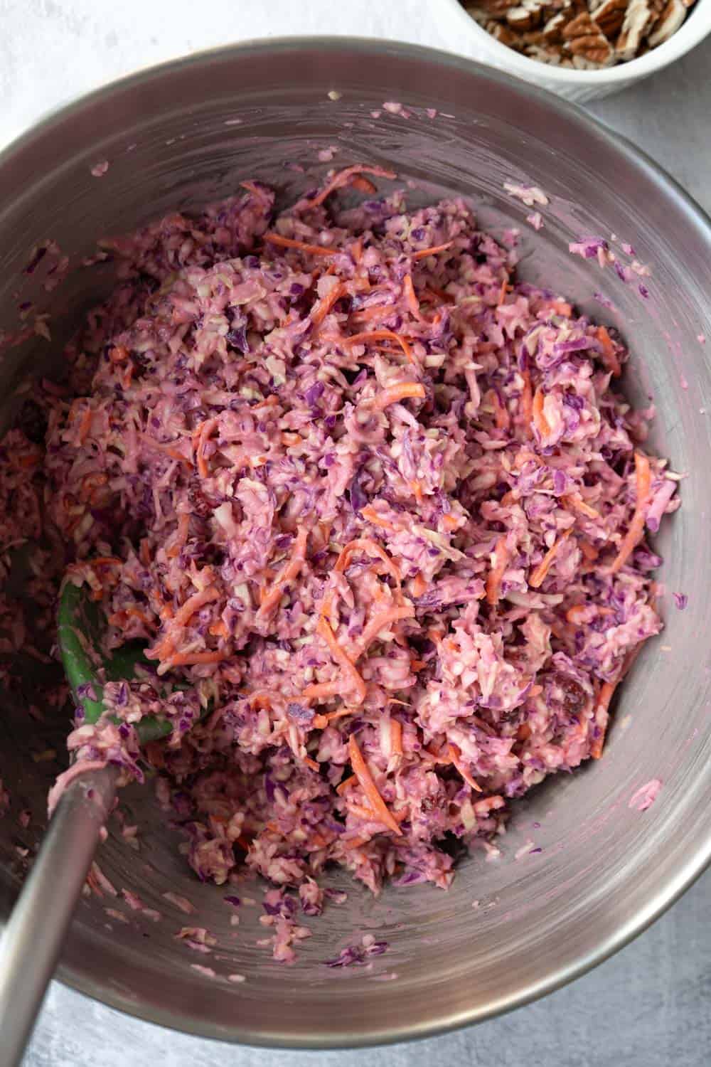 Stirring the cranberry slaw in a large bowl.