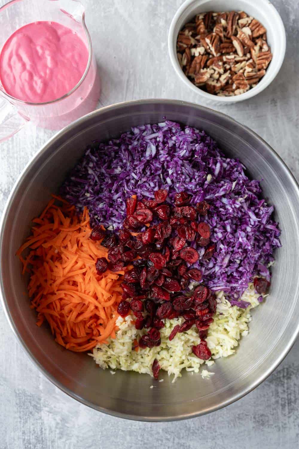 All of the slaw ingredients together in a large bowl ready to be tossed with dressing.