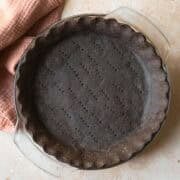 Baked chocolate pie crust on a tan countertop.