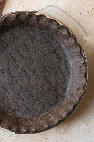Baked chocolate pie crust on a tan countertop.