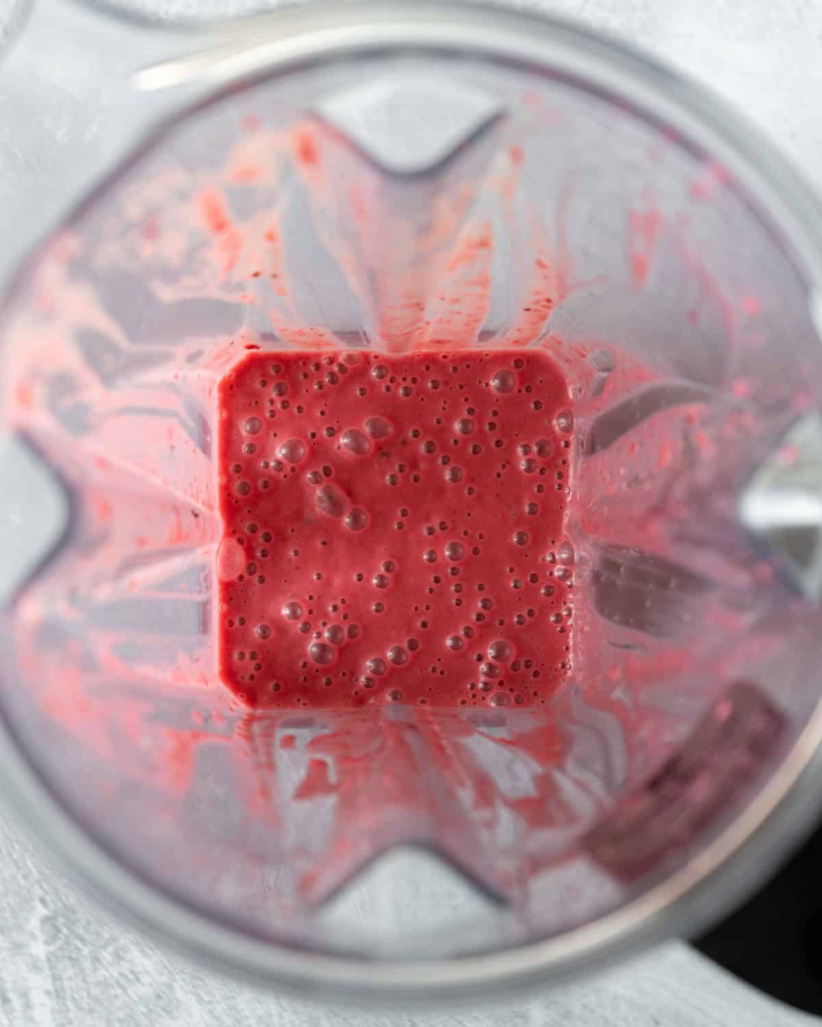 Looking inside a blender at the smooth and creamy dressing.