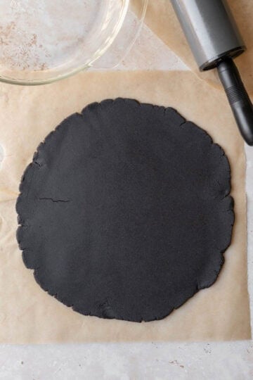 The chocolate dough rolled out on parchment paper.