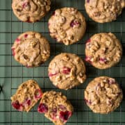 Orange cranberry oatmeal muffins with walnuts on a cooling rack.