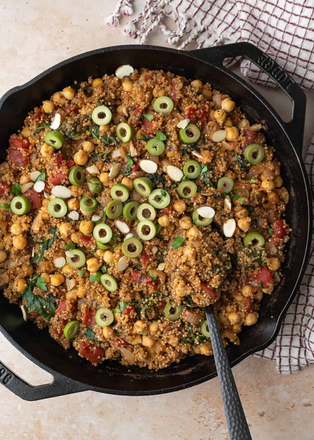 Quinoa with chickpeas, tomatoes, harissa and other Moroccan-inspired flavors in a skillet.