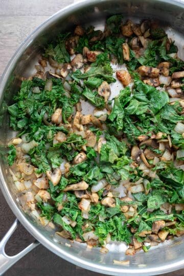 Chopped kale added to the saute pan.