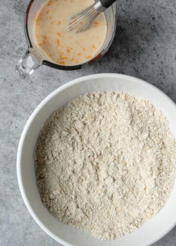Mixing dry and wet ingredients for muffin batter in separate bowls.