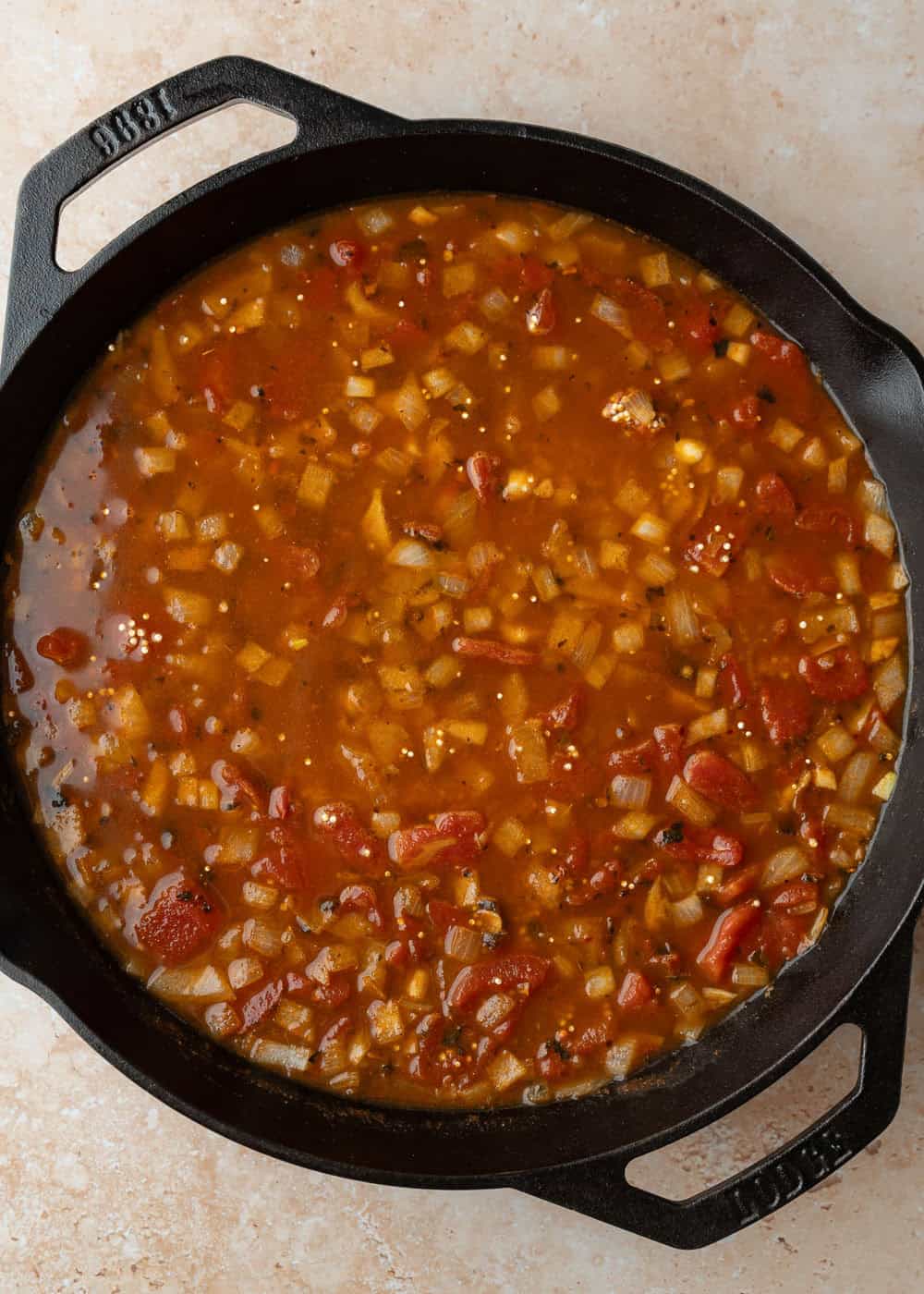 Adding diced tomatoes and water to the pot.