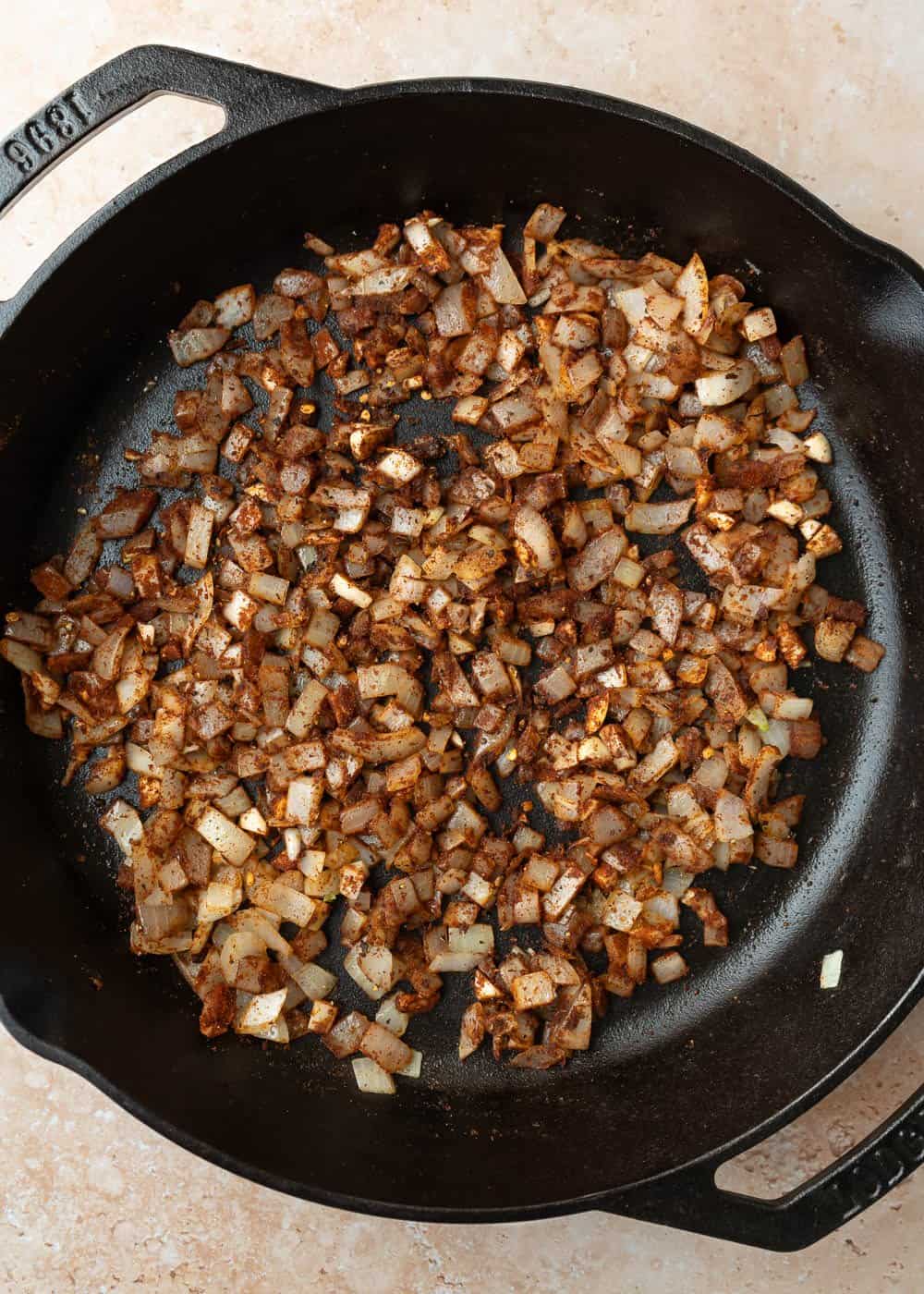 Sauteing onion with harissa to build flavor in the quinoa.