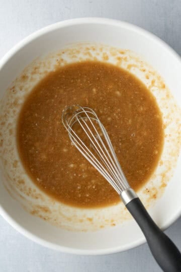 Whisking wet ingredients in a mixing bowl.