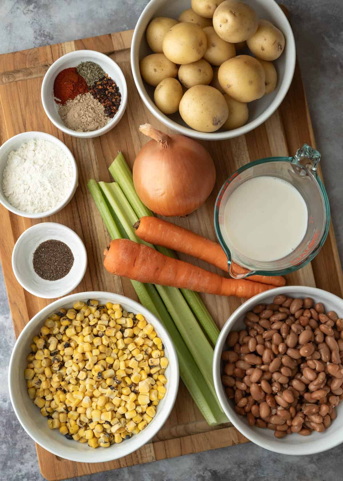 Ingredients needed for the soup measured and set on a wood board.