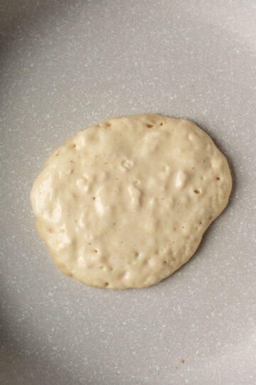Showing bubbles across the top of a pancake as it cooks.