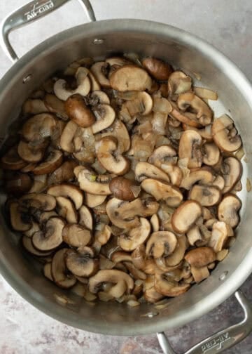 Sauteing onion and mushrooms in a large pot.