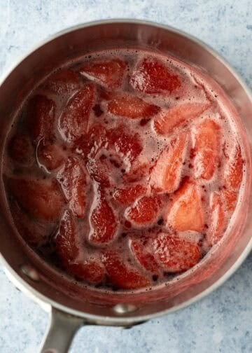 Strawberry syrup in a pot after the color and juice have seeped from the berries.