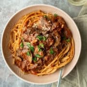 Overhead view of a pasta bowl filled with mushroom ragu over bucatini.