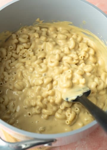 Folding cooked pasta into the creamy sauce.