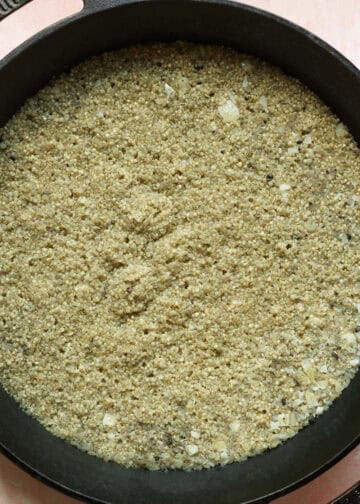 Lightly seasoned cooked quinoa in a skillet.