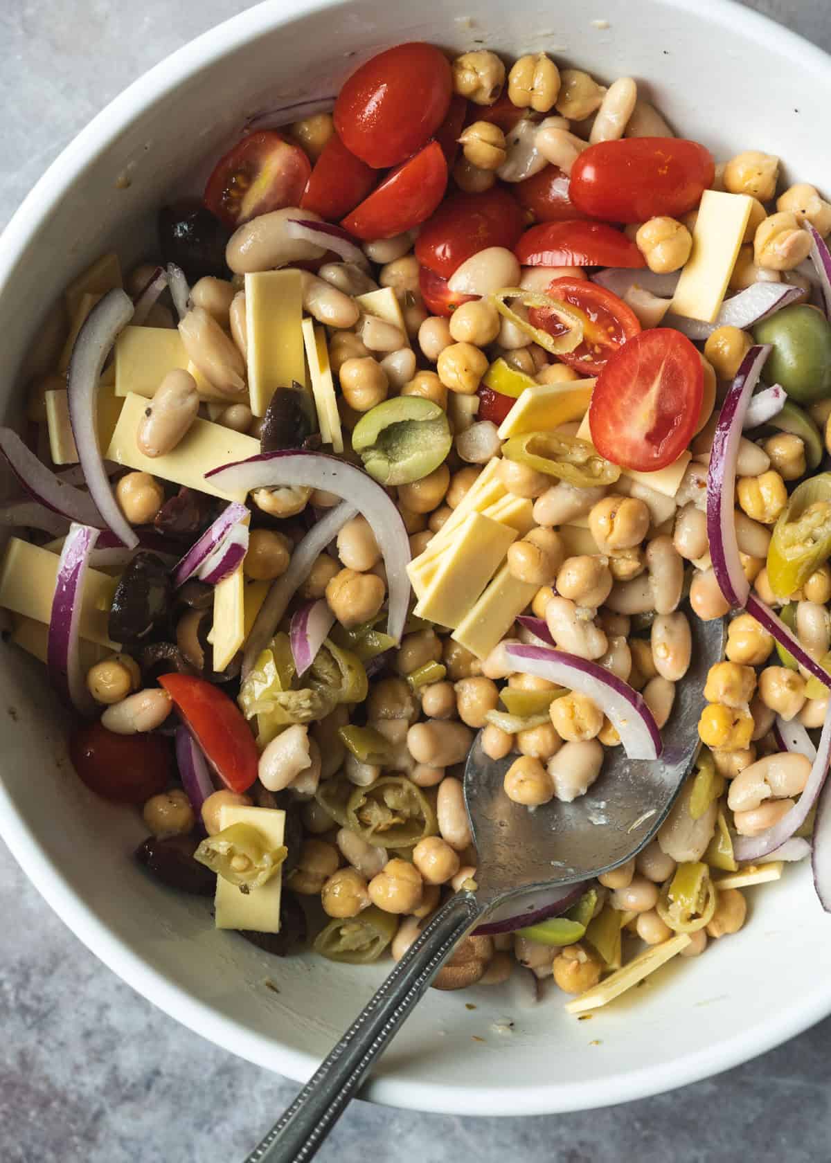 Tossing all of the dense bean salad ingredients together in a large bowl.
