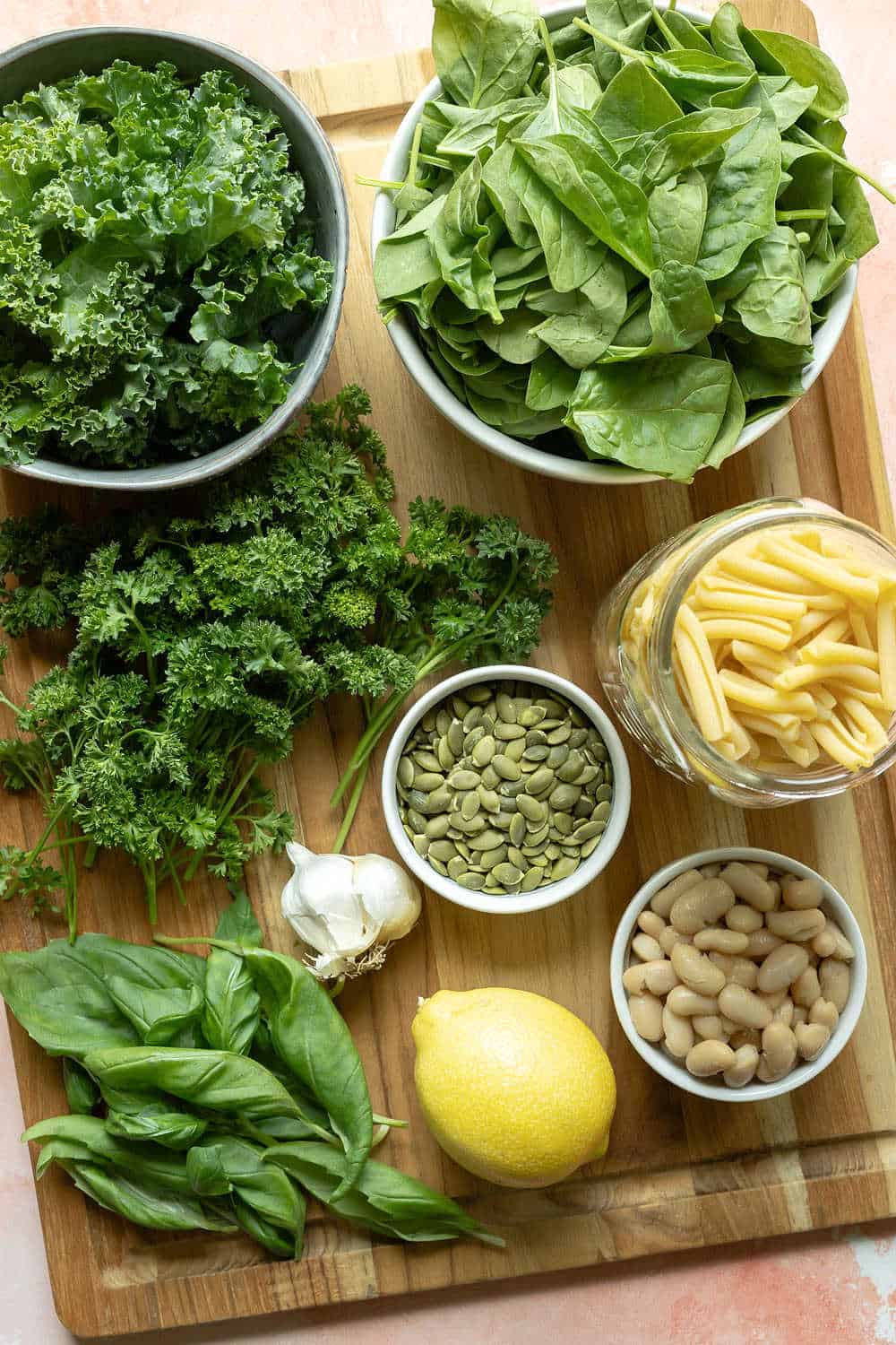 leafy greens, herbs, and other ingredients laid out on a cutting board.