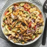 A serving bowl filled with vegan antipasto-inspired bean salad.