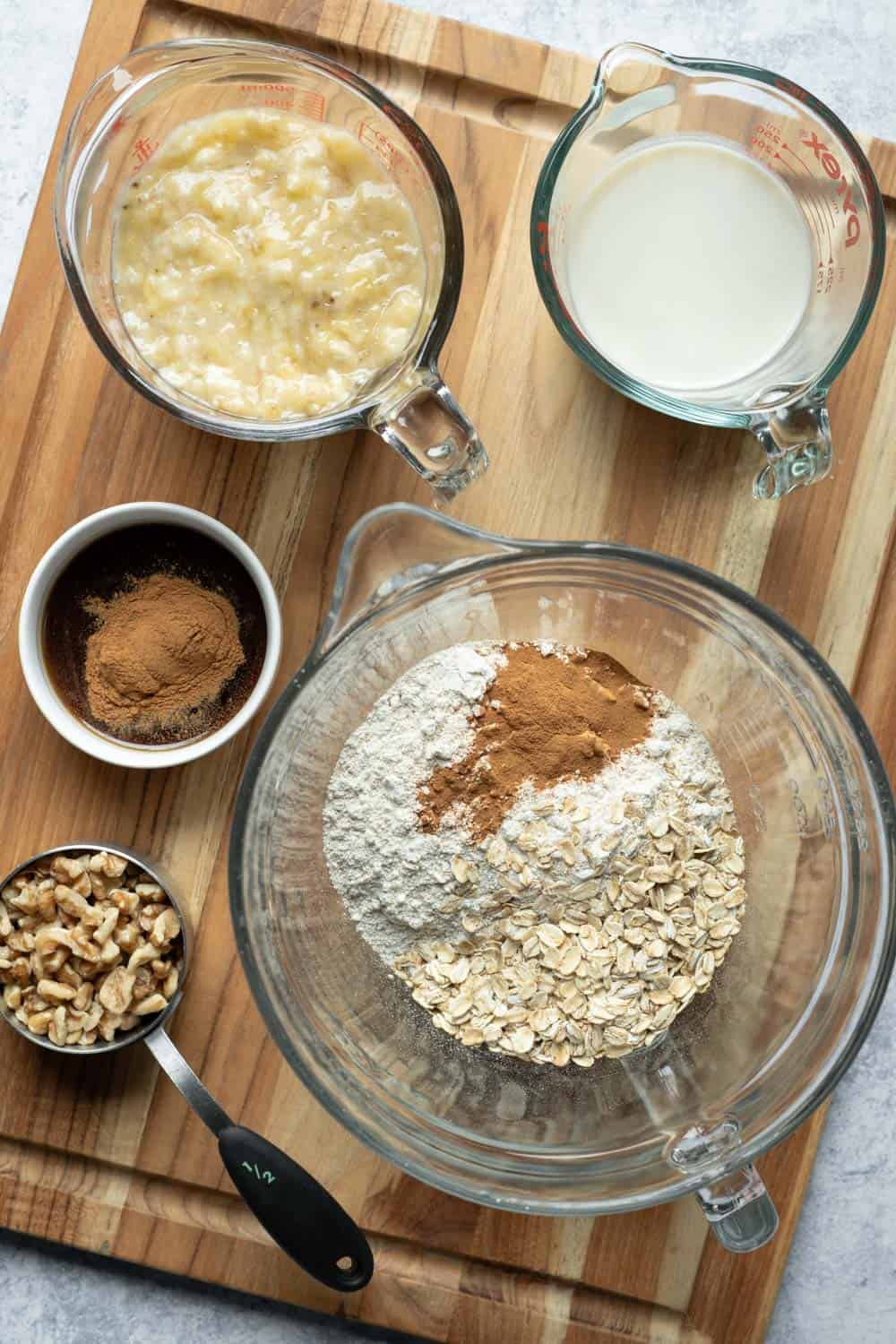 Ingredients for banana nut muffins on a wood board.