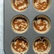 Adding cinnamon swirl to batter in muffin pan.