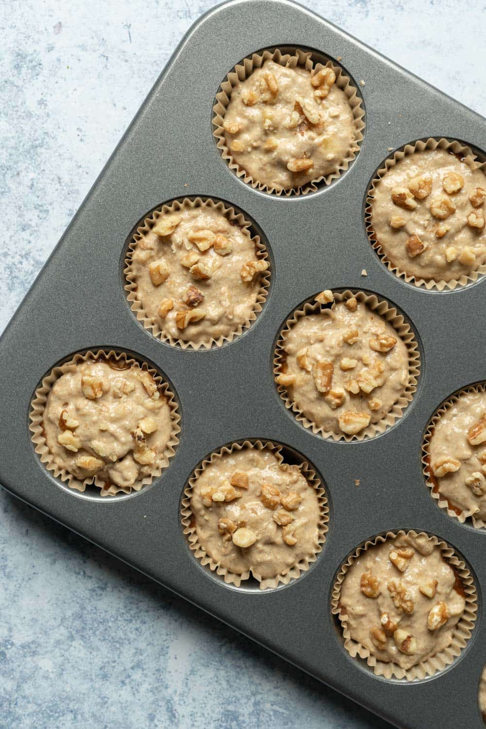 Batter in pan with walnuts crumbled on top.