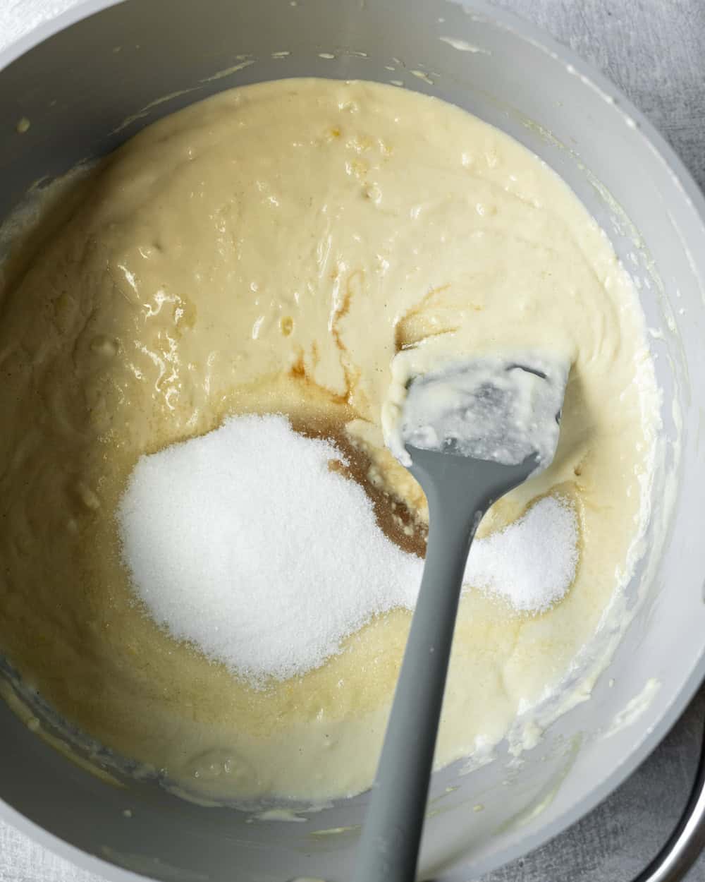 Stirring sugar and vanilla into the simmered ice cream base.