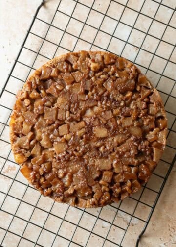 Freshly baked upside down applesauce cake on a cooling rack.