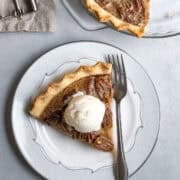 A slice of vegan pecan pie topped with dairy-free ice cream.
