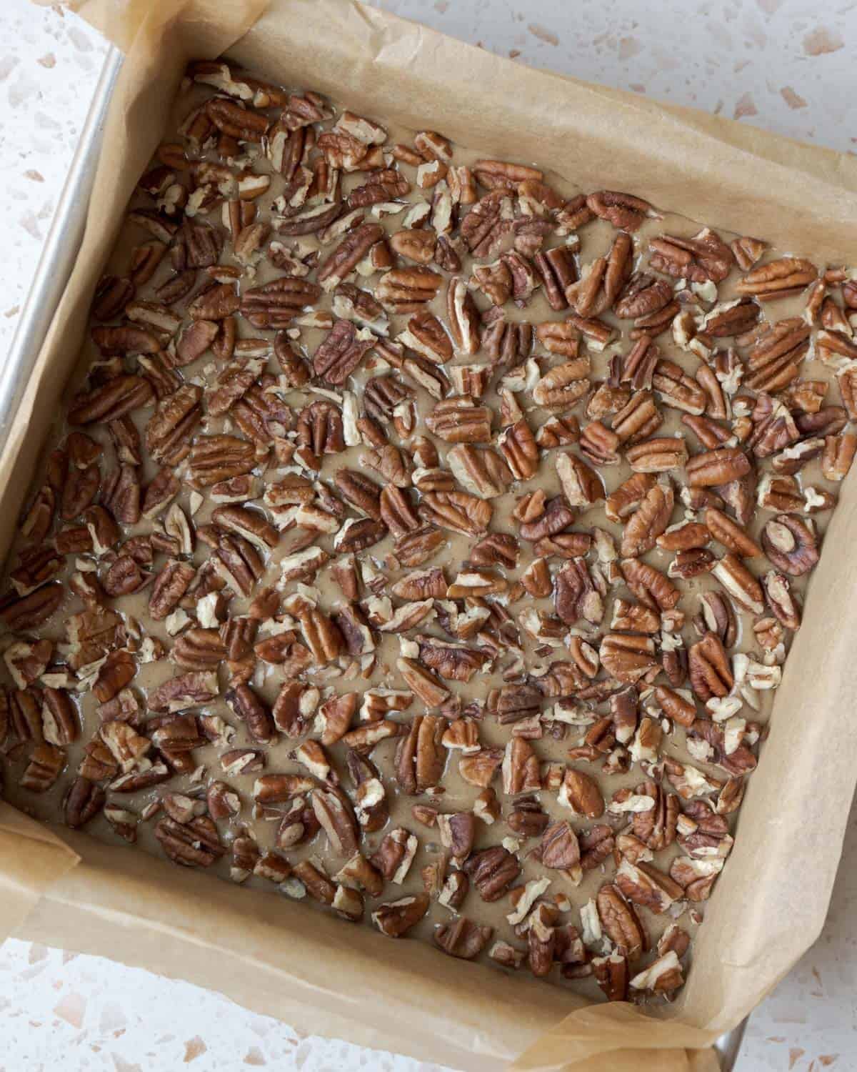 Ready for the oven, with chopped pecans spread across the filling.