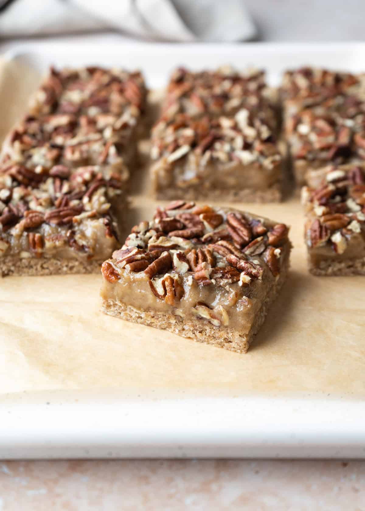 Sliced pacan pie bars with one close up to show the gooey filling and crunchy pecans.