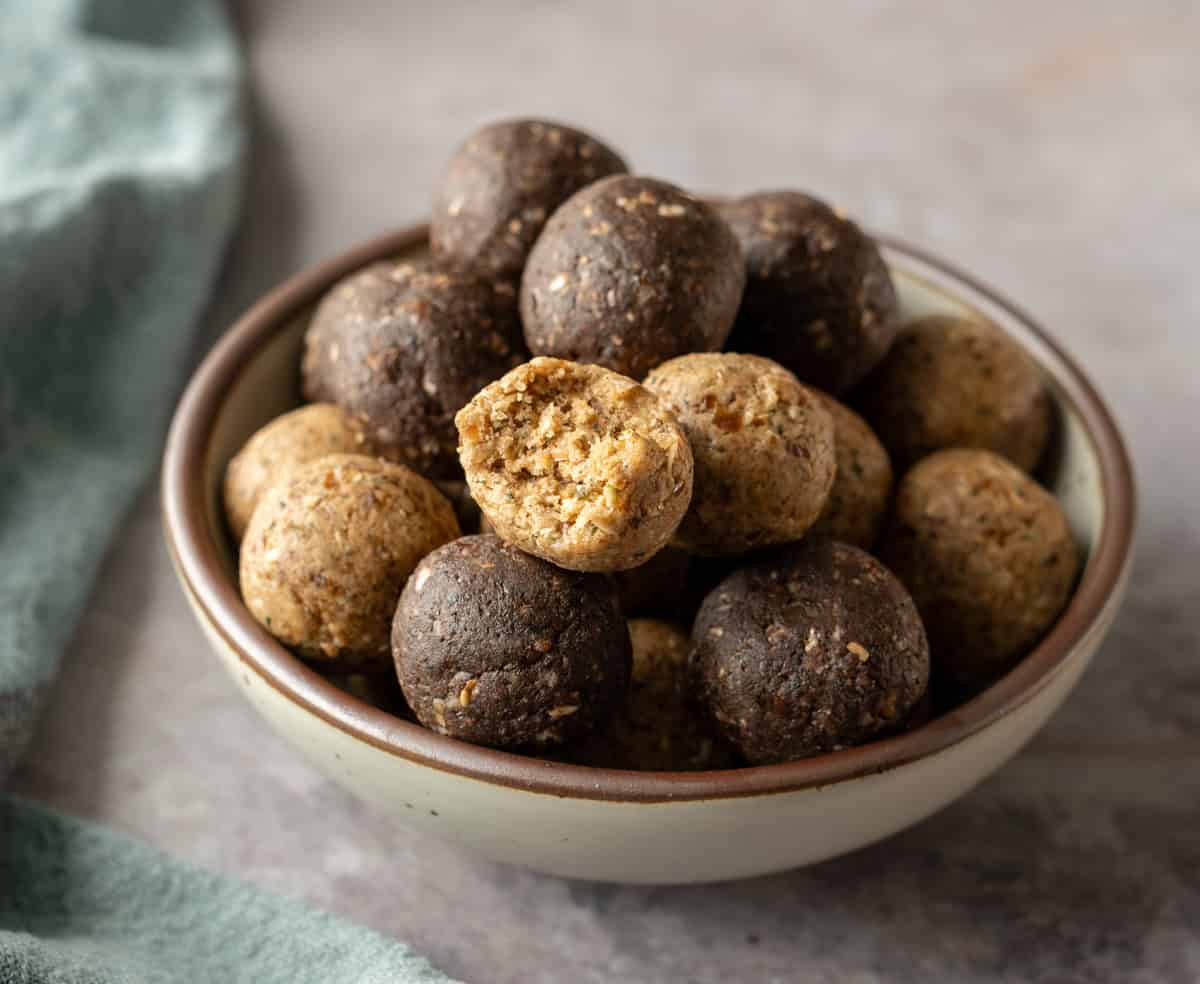 A bowl filled with both vanilla and chocolate protein bites.